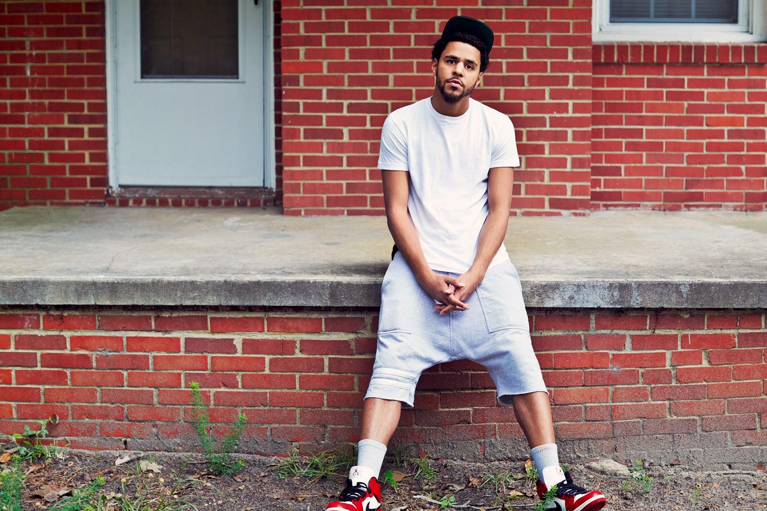 Man leaning agains a concrete patio looking at the camera