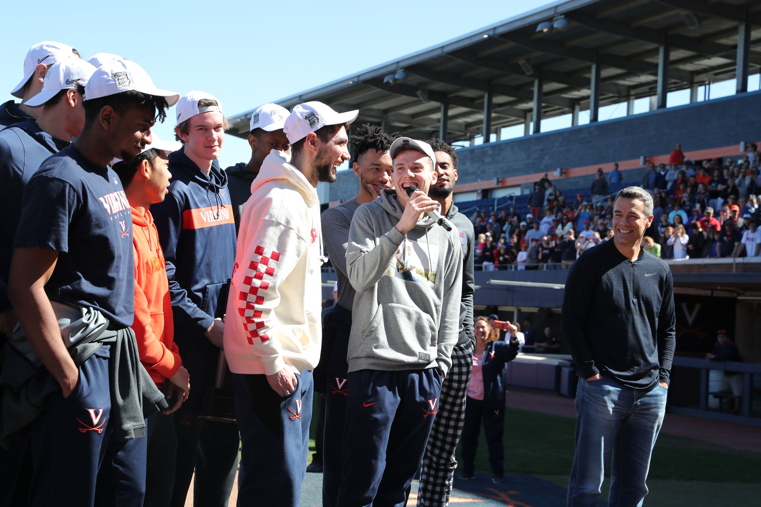 UVA basketball team speaking into a microphone during a celebration