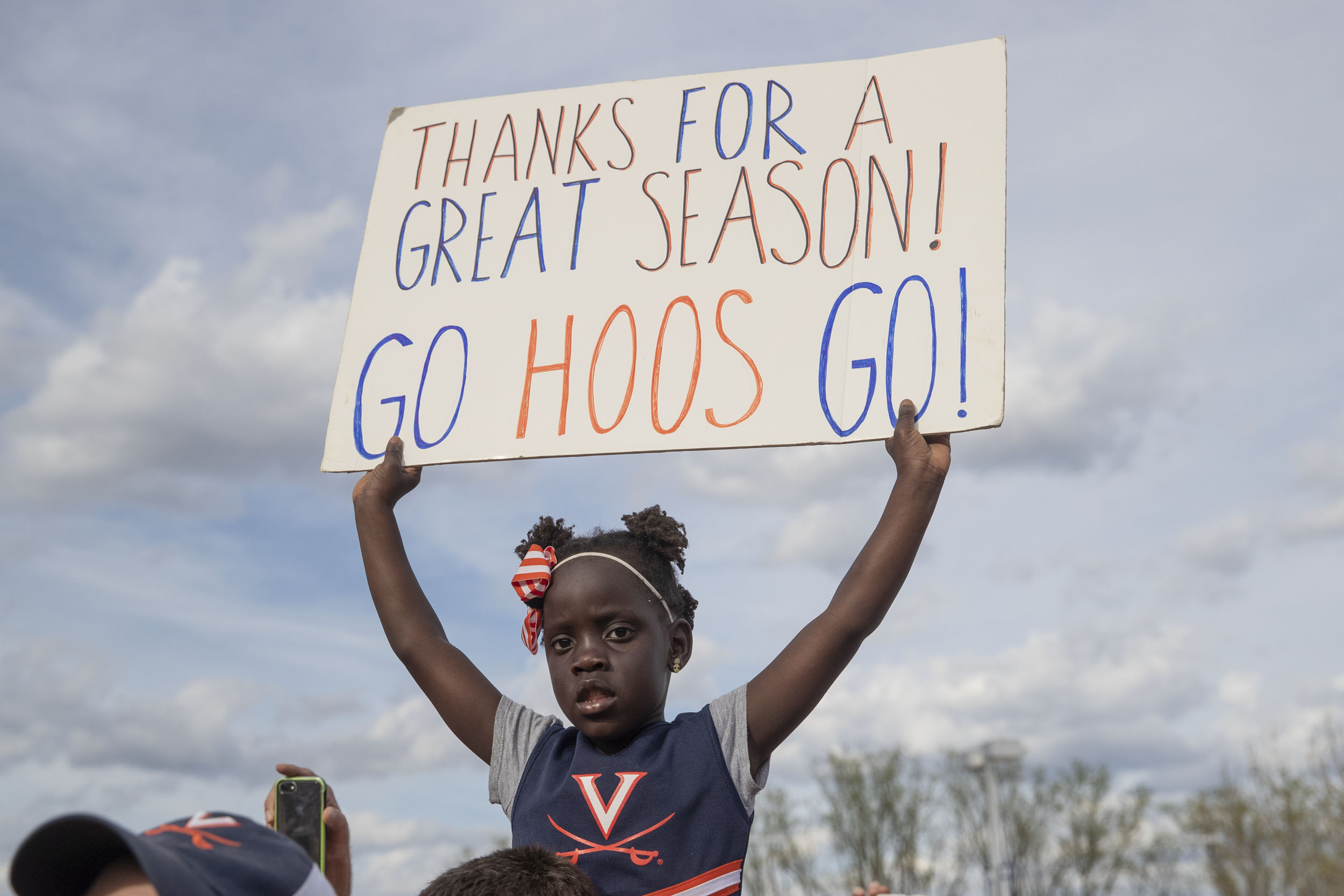 Little girl holds a sign that reads Thanks for a Great Season Go Hoos Go!