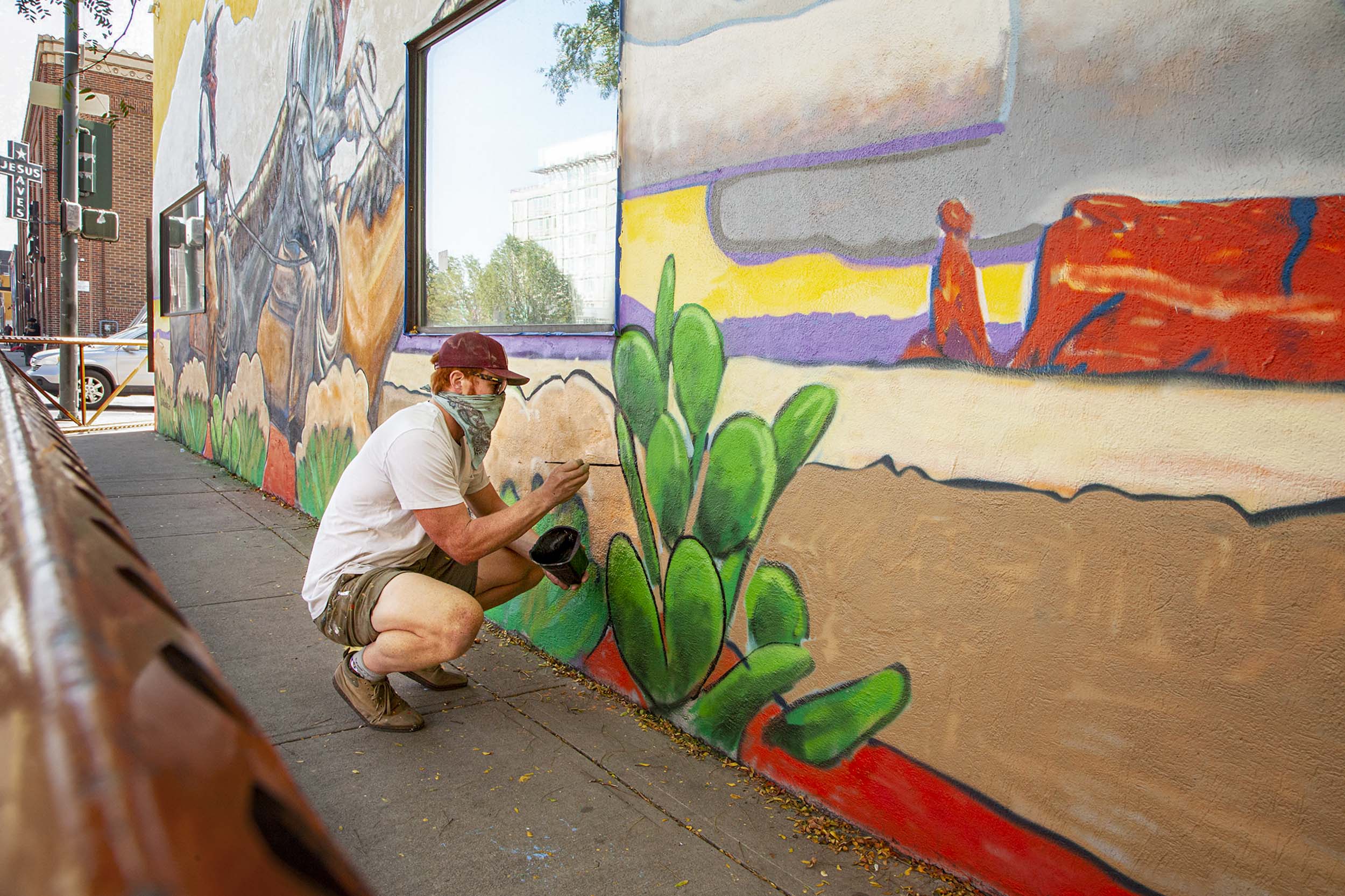 Will Baker painting a mural on the outside of a building