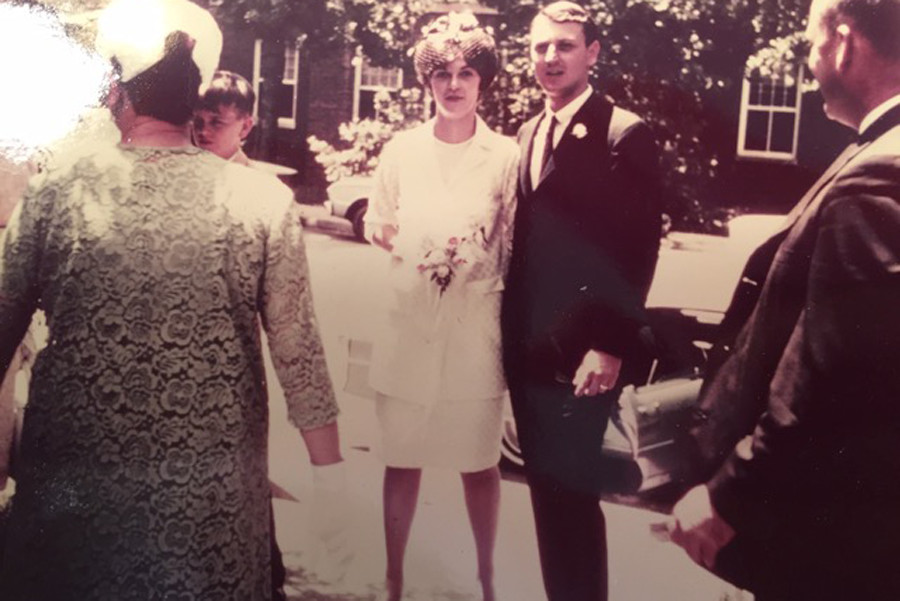 Bride and Groom stand together while people gather around