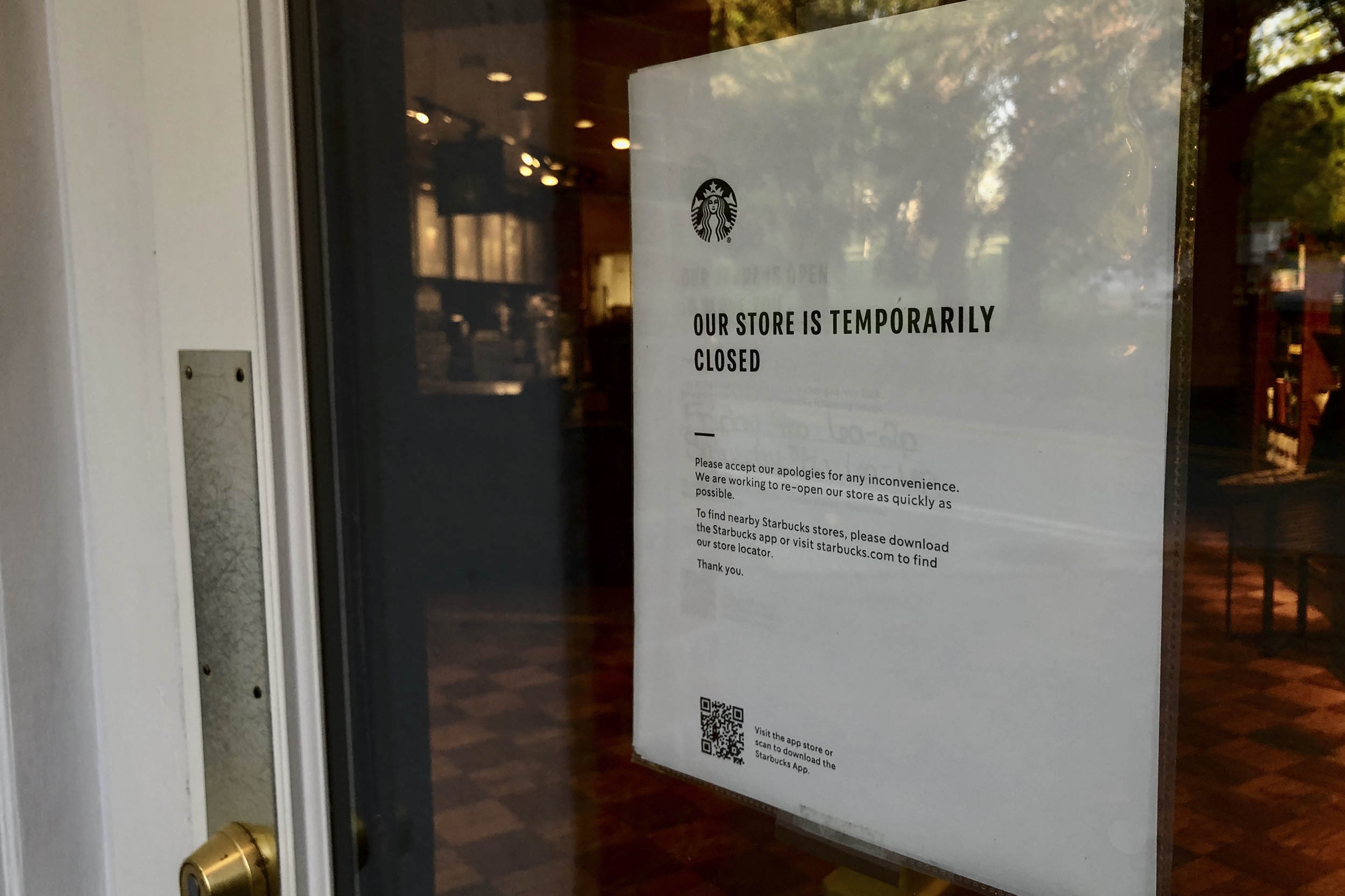 Sign on a door that reads: Our store is temporarily closed