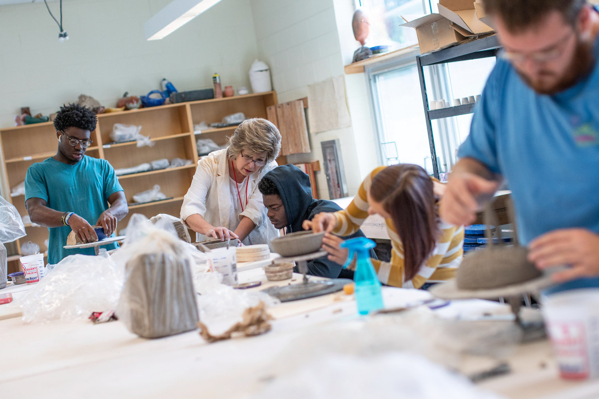 UVA Wise professor helping a pottery student 