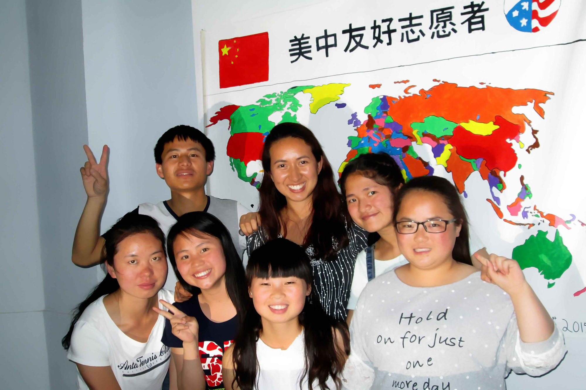 Loverde and her students pose in front a Peace Corps World Map their class created.