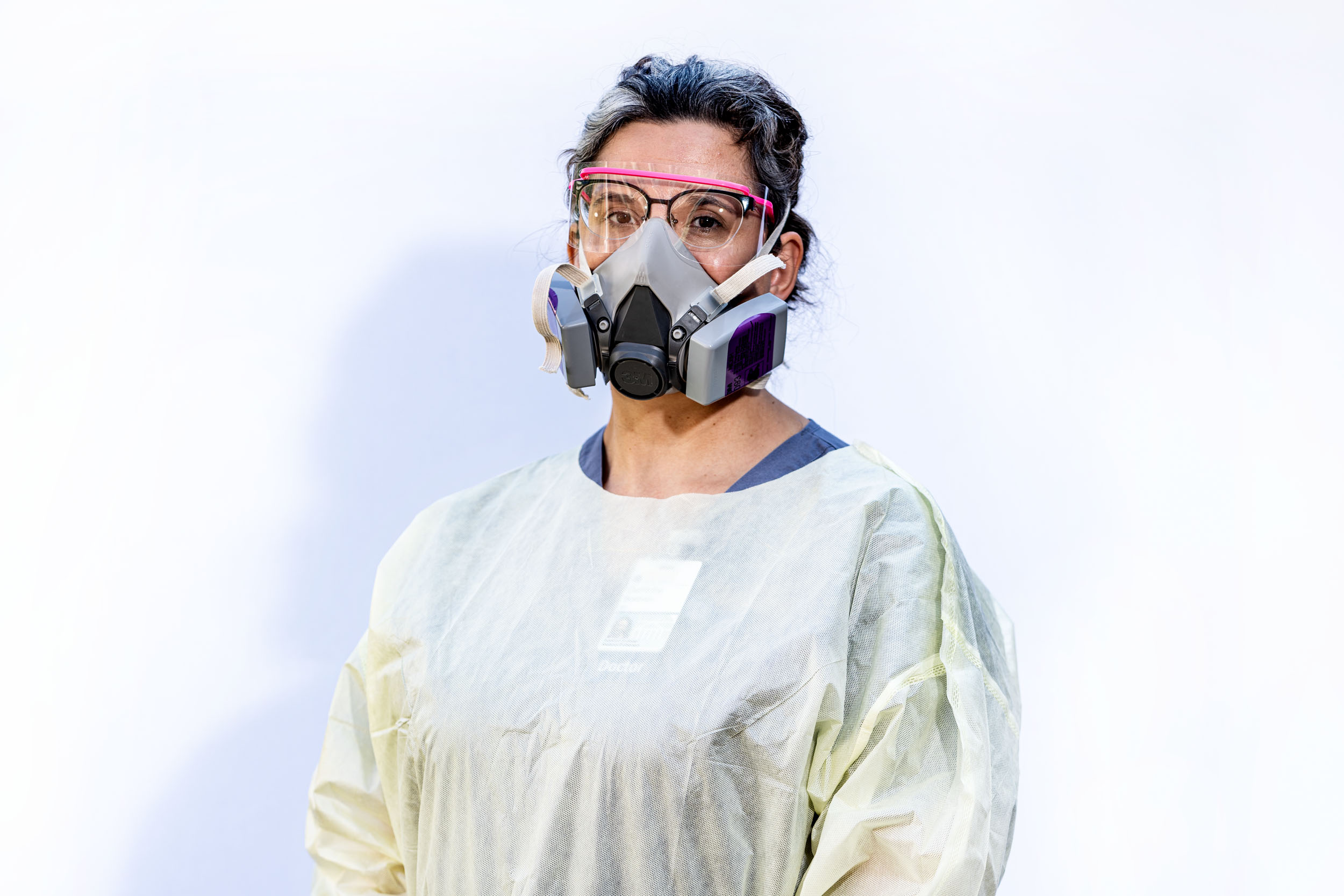 Medical Professional wearing a medical gown, face shield, and gas mask