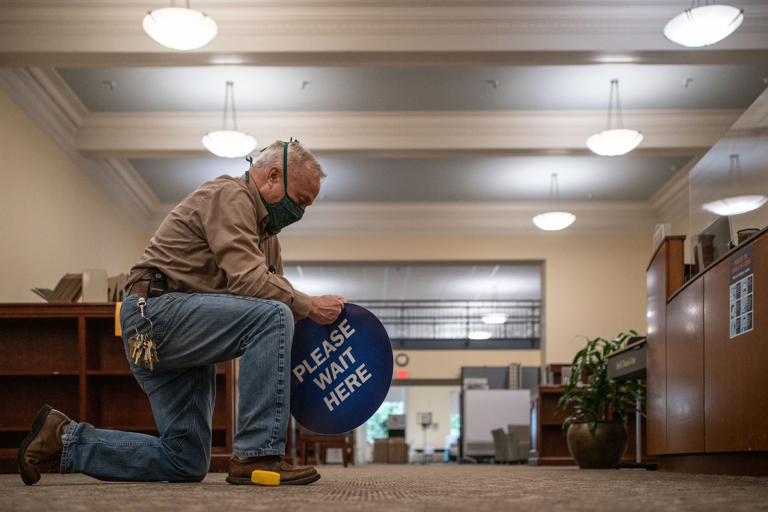 Guy Mengel working on placing a Please Wait Here sticker on the floor