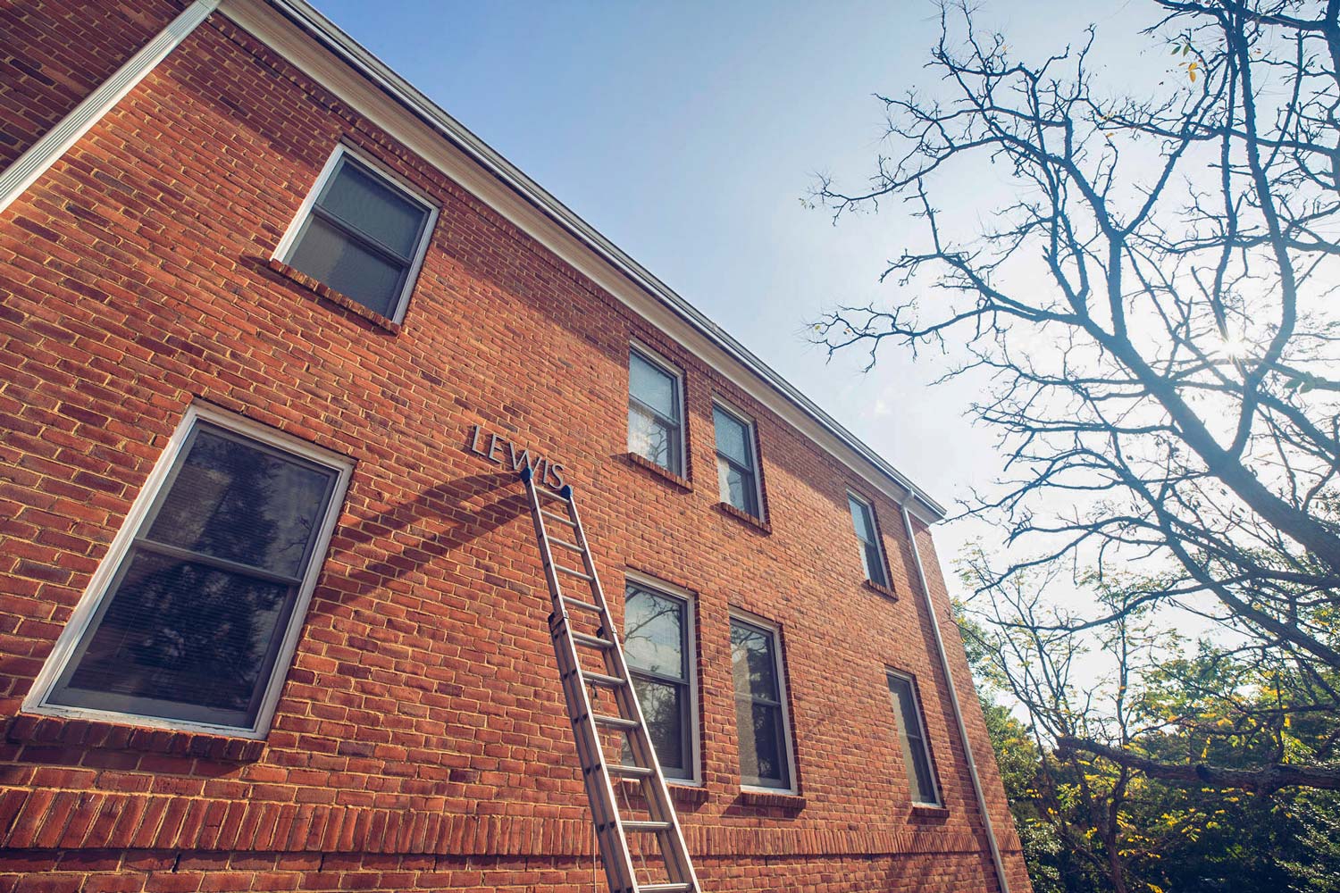 Lewis Hall with a ladder on the building