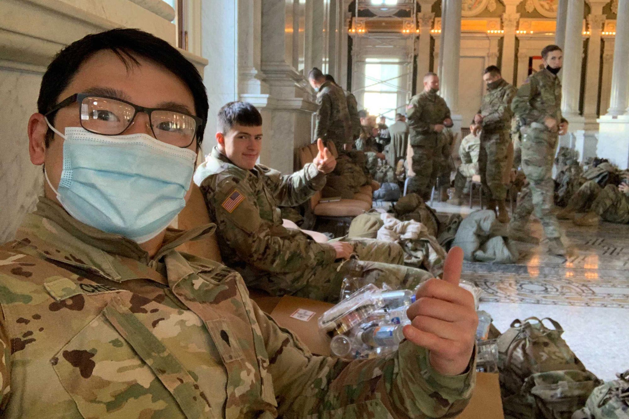 UVA's Ziniu Chen giving a thumbs up with another service men while sitting on the floor in the US Capital
